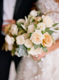 the bride and groom are holding their bouquets