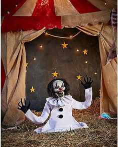 a creepy clown dressed in white and holding his hands up to the side with stars on it