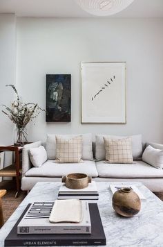 a living room filled with furniture and a painting on the wall above it's coffee table