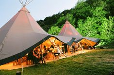 a group of people standing outside of a tent