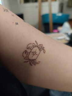 a tattoo on the arm of a woman with a crab and starfish in it