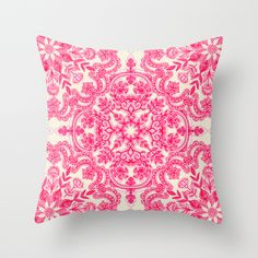 a pink and white pillow with an intricate design