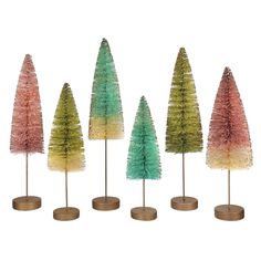 five small trees in different colors on wooden bases