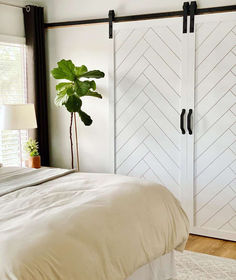 a bedroom with a bed and two sliding closet doors on the wall next to it