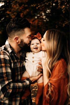 a man and woman holding a baby in their arms