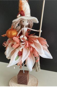 a figurine is dressed in an orange and white outfit with flowers on it