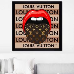 the louis vuitton poster is hanging on the wall next to a couch with pillows