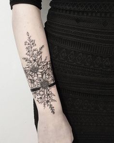 a woman's arm with a flower tattoo on it