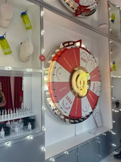 a woman is standing in front of a wheel of fortune on display at a store