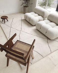 a living room filled with lots of furniture and a plant in the window sill