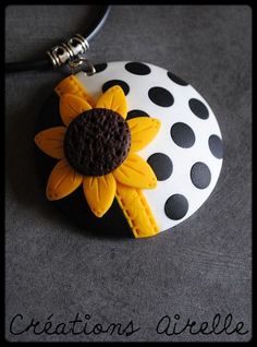 a black and white polka dot necklace with a yellow sunflower on the front side