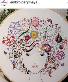 a woman's face with flowers and butterflies painted on the side of a hoop