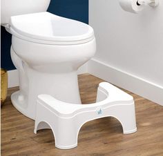 a white toilet sitting on top of a hard wood floor