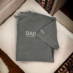 "These embroidered Dad T-shirts make a great Father's Day gift! Customized with the year they became a dad and the kids initials on the sleeve! **If you would like this shirt customized beyond adding the est. year and initials on the sleeve, please email us first to make sure that the changes are possible. There will be a $10 charge for extra customization outside of est. year and initials. We will then let you know to pick the \"extra customization\" option in the color selection in the size you need. When doing this please put the color shirt you would like from the available options in the personalization box along with your other customizations.**  ORDERING & SHIPPING *Your item will be shipped within 5-7 business days. *Please allow 2-5 business days to receive your item, more time ma