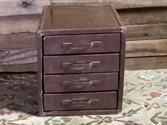 an old metal file cabinet sitting on top of a rug