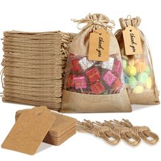 two bags filled with assorted candies next to some tags and twine string