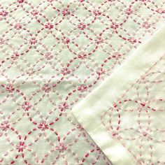 two pieces of white fabric with pink flowers on them