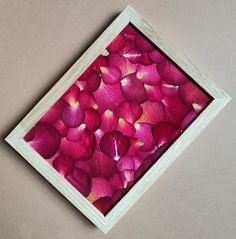 a wooden frame with pink petals in it