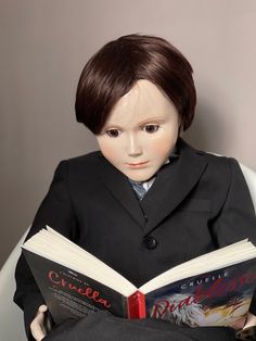 a doll wearing a suit and tie reading a book