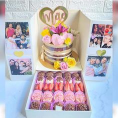 a cake with flowers and pictures on it in a box next to two boxes filled with candies