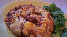 a yellow plate topped with lasagna and lettuce