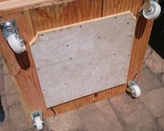 an unfinished wooden cabinet with two toilet paper dispensers attached to the sides