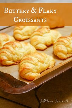 freshly baked croissants sitting on top of a baking sheet