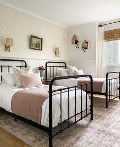 two beds in a bedroom with pink and white bedding