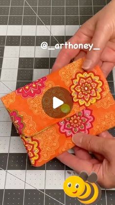 someone is making an origami card holder out of fabric and some paper flowers