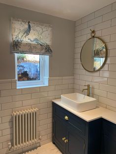 a white sink sitting under a window next to a radiator in a bathroom