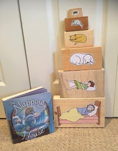 three wooden blocks with pictures of animals on them and a book in front of the door