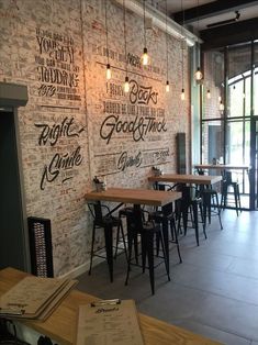 an empty restaurant with brick walls and wooden tables