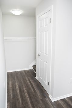 an empty room with wood floors and white walls