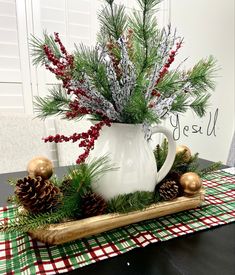 a white coffee cup filled with pine cones and greenery