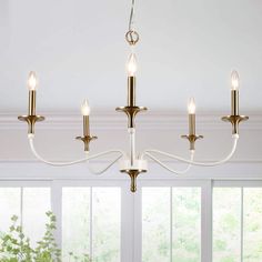 a chandelier with five lights hanging from it's ceiling in a living room