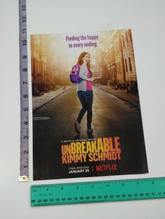 a movie poster on the side of a ruler next to a piece of paper that says,'unbreakable kimmy schmot '