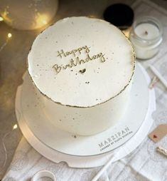 a white birthday cake sitting on top of a table