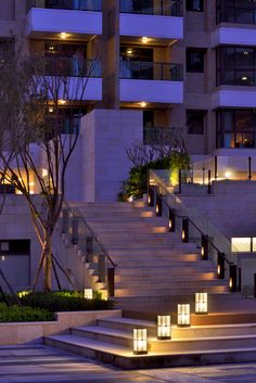 the stairs are lit up at night in front of an apartment building