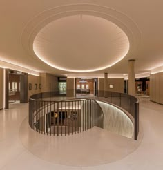 a circular staircase in the middle of a large building with lights on either side and an open door leading to another room