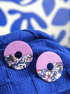 two pairs of pink and blue buttons sitting on top of a blue sweater