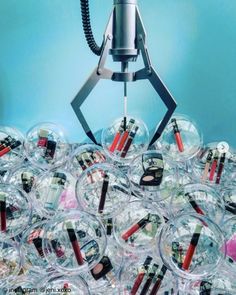 a machine that is sitting on top of some glass balls with lipstick in it's mouth