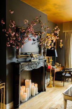 a living room filled with lots of furniture and flowers on top of a fire place