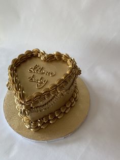 a heart - shaped cake on a plate with the word love is spelled in gold