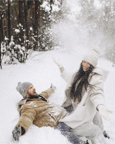 a man and woman playing in the snow