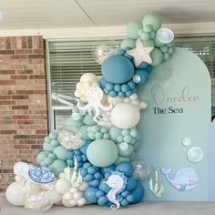 an under the sea themed birthday party with balloons and decorations on display in front of a window