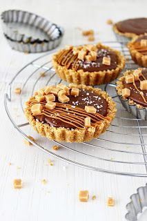 four mini chocolate tarts cooling on a wire rack