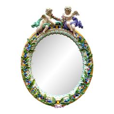 a mirror with two cherubs sitting on top of it