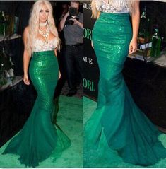 two women in green dresses standing next to each other on a green carpeted floor