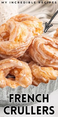 a bunch of doughnuts sitting on top of a metal pan with the words french crullers below it