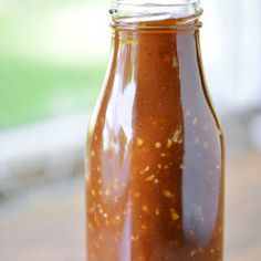 a jar filled with brown sauce sitting on top of a table